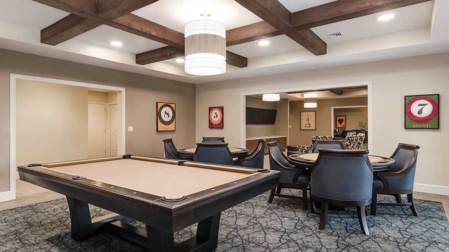 Game room with billiard table at American House Coconut Point, a senior living community in Estero, FL