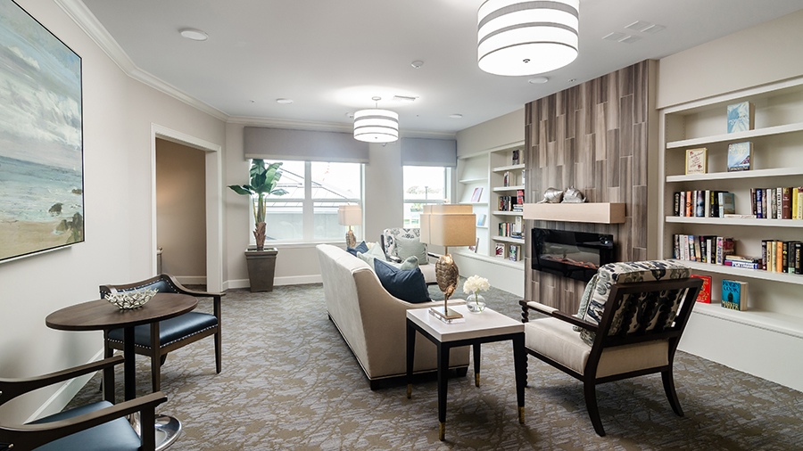 Cozy library with fireplace at American House Ft. Myers assisted living and memory care facility in Fort Myers, FL