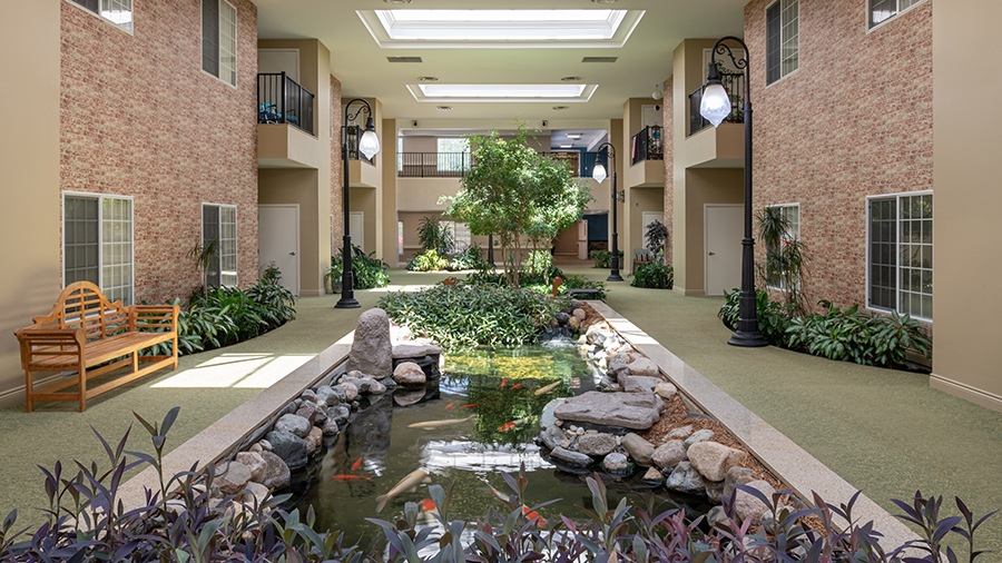 Peaceful atrium with koi pond at American House Park Place senior living facility in Warren, MIk