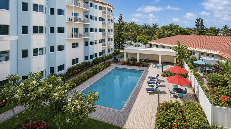 View of outdoor pool with patio at American House The Palms senior living community in North Fort Myers, FL