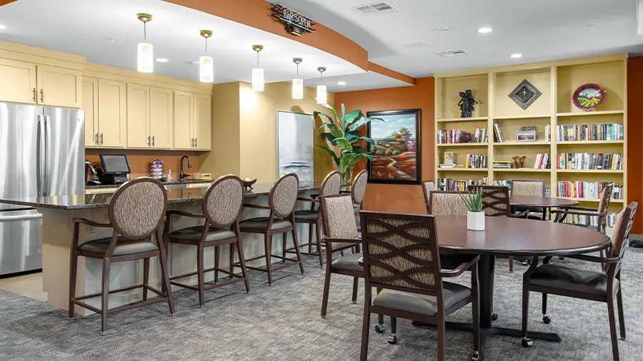 Bistro and library with counter and game table at American House St. Anthony's Independent Living, Assisted Living, and Memory Care senior living facility in Kansa City, MO
