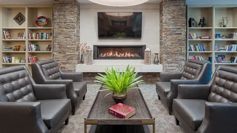 Cozy lounge with fireplace at American House St. Anthony's senior living community in Kansas City, MO