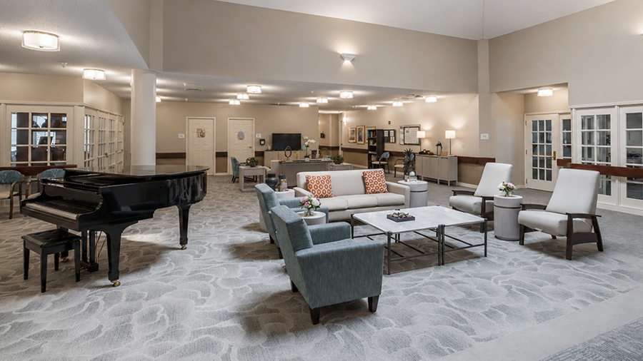 Lobby with seating and grand piano at American House Johnson City Assisted Living and Memory care facility in Johnson City, TN