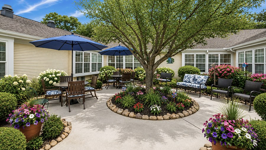Outdoor patio with flowers and seating at American House Kingsport Assisted Living and Memory care facility in Kingsport, TN