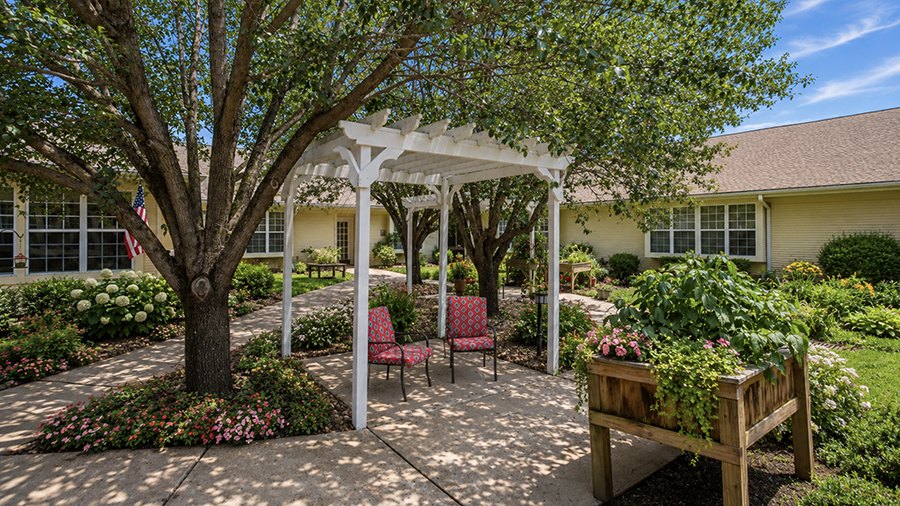 Peaceful courtyard with flowers and seating at American House Murfreesboro Assisted Living and Memory care facility in Murfreesboro, TN
