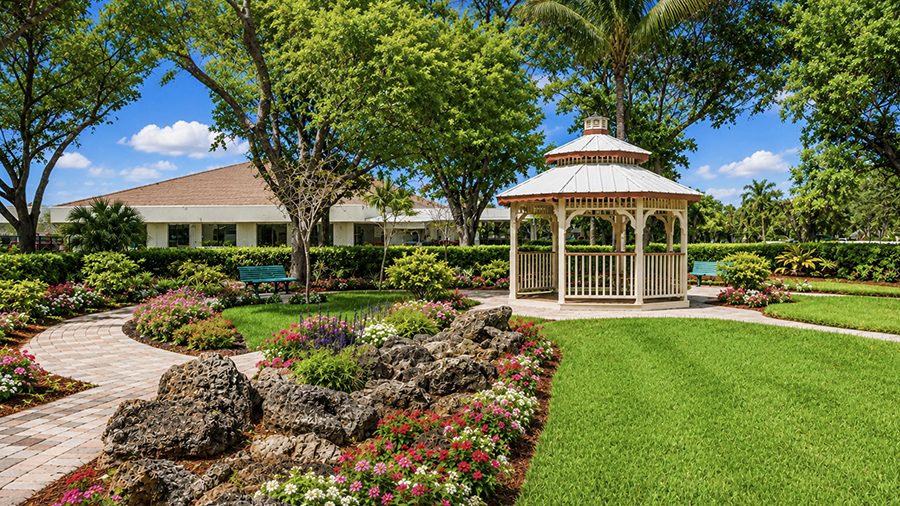 Walking path and gazebo in courtyard at American House The Palms senior living community in North Fort Myers, FL