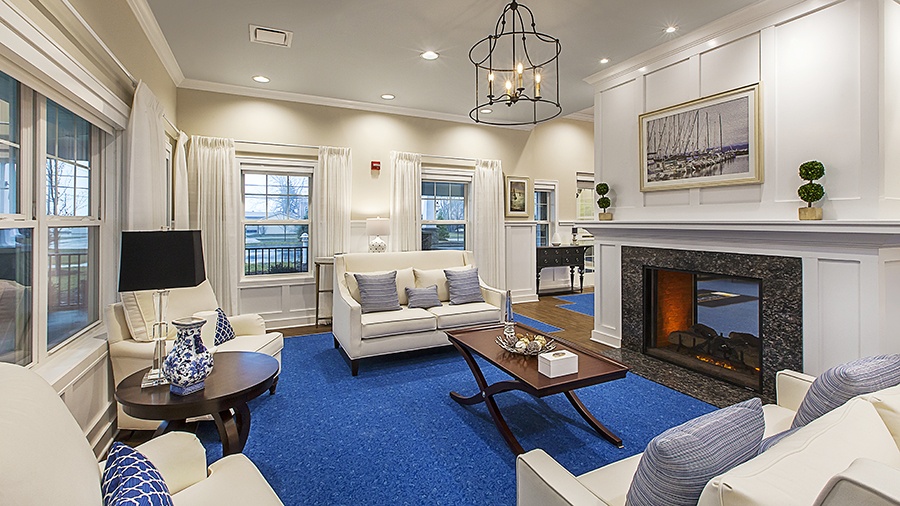 Cozy seating with fireplace in main Foyer at American House Lakeshore senior living and memory care facility in Roseville, MI