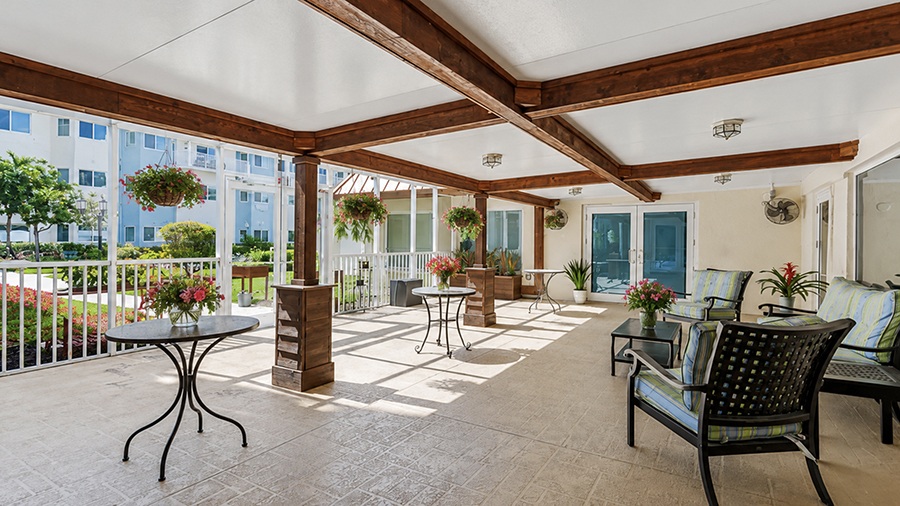 Sunny lanai with seating at American House The Palms senior living community in North Fort Myers, FL
