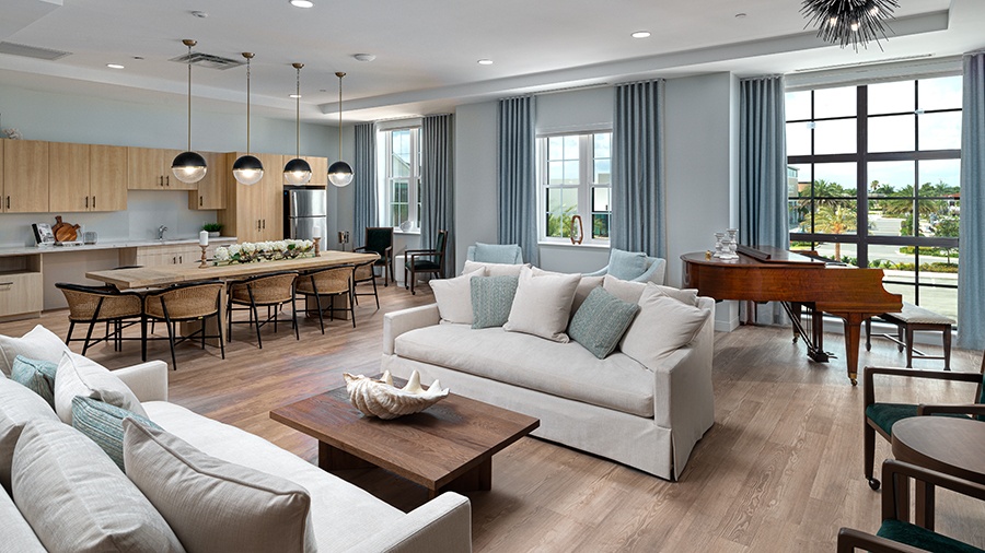Community space with bistro, couches and piano at American House Boynton Beach, a retirement home in South Florida