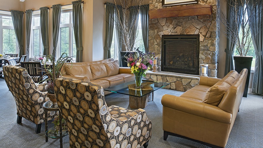 Cozy lobby with fireplace at American House Jenison senior living facility in Jenison, MI