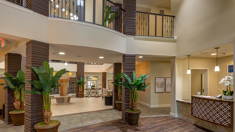 Atrium with lobby and concierge at American House Coconut Point, a senior living community in Estero, FL