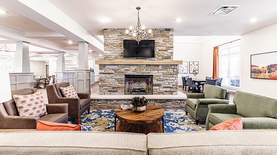 Great room with fireplace and comfy seating at American House Mount Prospect assisted living and memory care facility in Mt. Prospect, IL