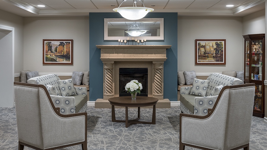 Cozy sitting area with fireplace at American House assisted living and memory care facility in Zephyrhills, FL