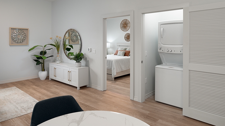 Model apartment showing bedroom, laundry and living room at American House Boynton Beach, a retirement home in South Florida