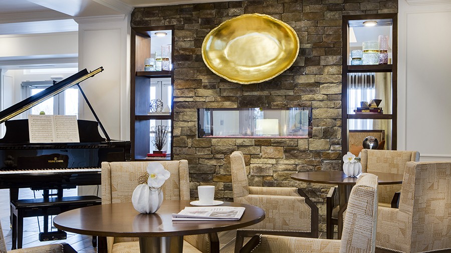 Lounge with piano at American House Burlington Creek Assisted Living and Memory Care Facility in Kansas City, MO