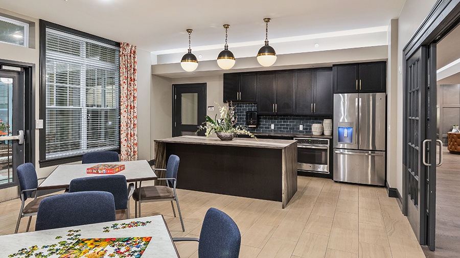 Activity room with games, puzzles and a kitchen at American House Somerset assisted living and memory care facility in Troy, MI