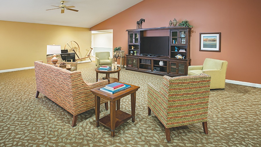 Cozy common area with vintage spinning wheel at American House Charlevoix senior and assisted living facility