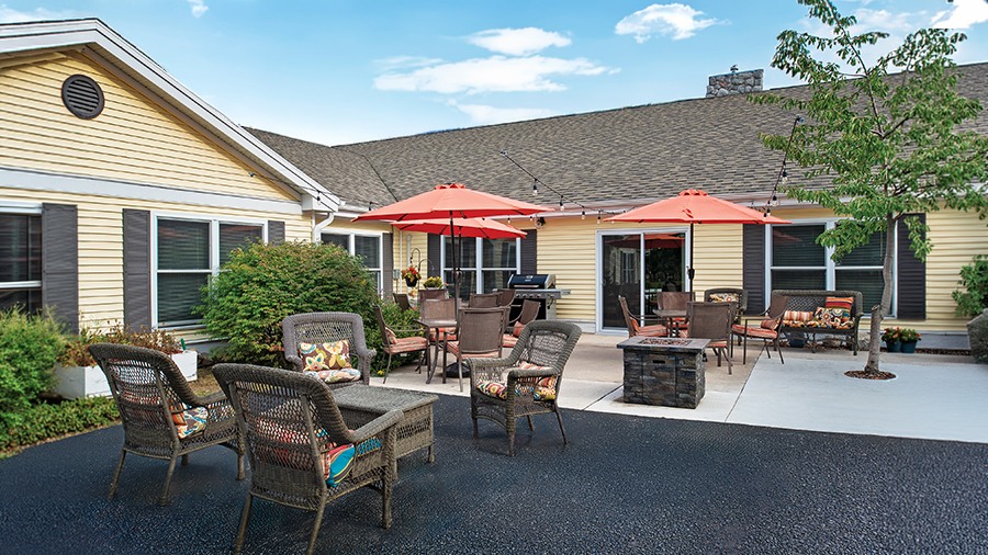 Outdoor patio with seating and firepit at American House Charlevoix senior and assisted living facility
