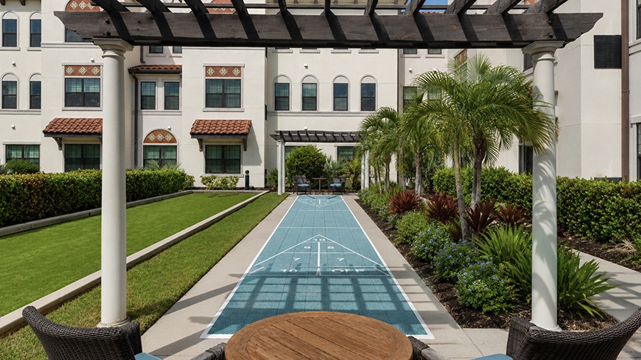 Outdoor suffleboard at American House Coconut Point, a senior living community in Estero, FL