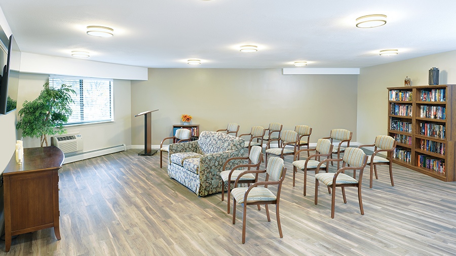 Community room with lectern, books and seating a at American House Grand Blanc assisted living community