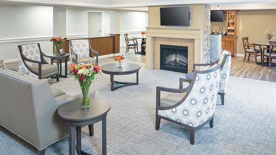 Lobby seating with fireplace and bistro at American House Grand Blanc assisted living community