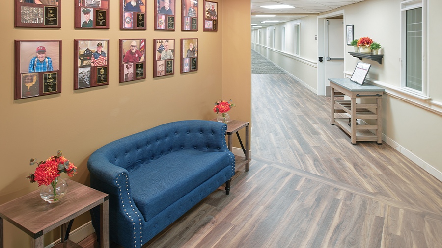 Veteran wall of honor with seating and pictures of residents who served at American House Grand Blanc assisted living community