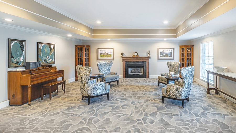 Cozy lounge with fireplace and piano at American House in Chattanooga assisted living and memory care facility
