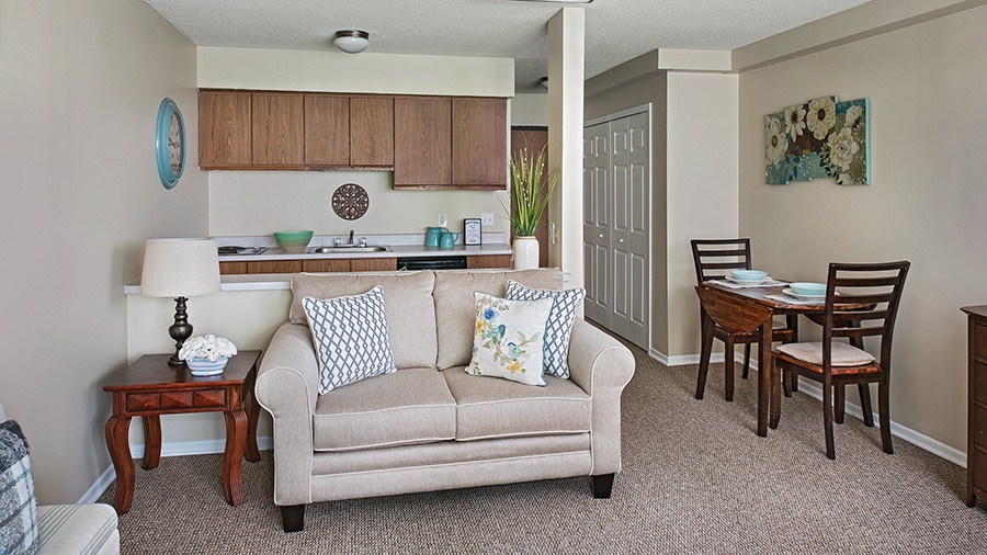 Living room and kitchen in an apartment at American House Livonia, a senior living community in Livonia, Michigan