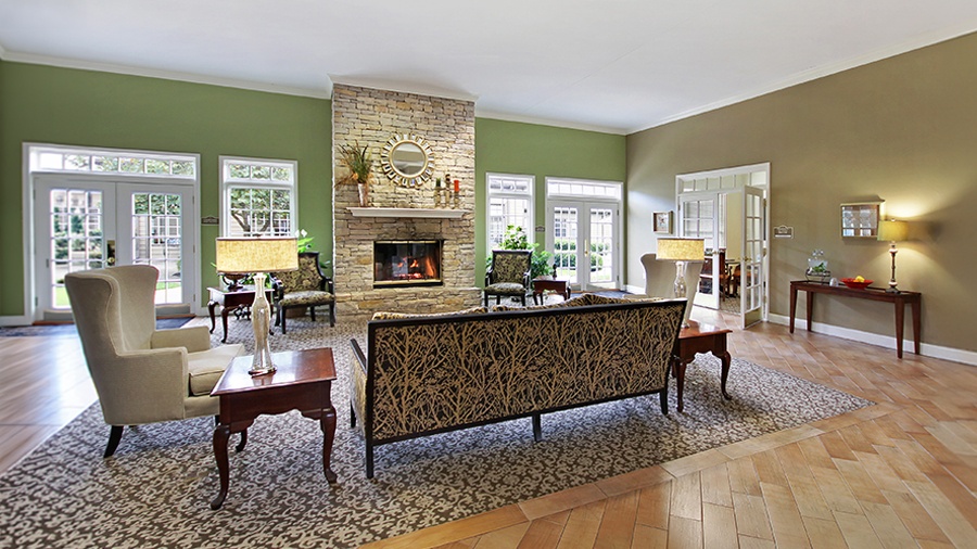 Lobby and cozy sitting area with fireplace and outdoor patio at American House Brentwood, a senior living community in Nashville, Tennessee