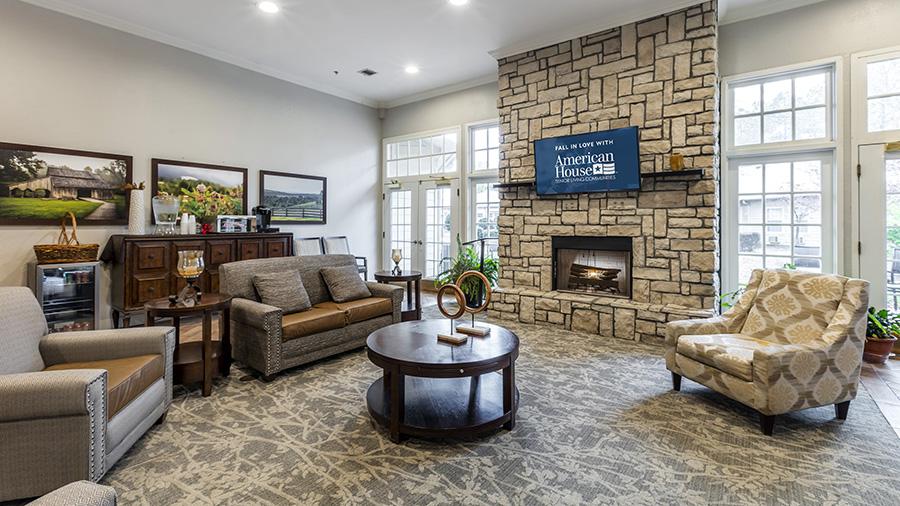 Cozy sitting area with fireplace at American House Bartlett assisted living facility in Bartlett, TN