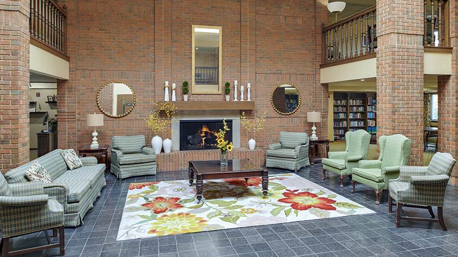 Lobby and cozy fireplace at American House East I independent living and assisted living facility in Roseville, MI