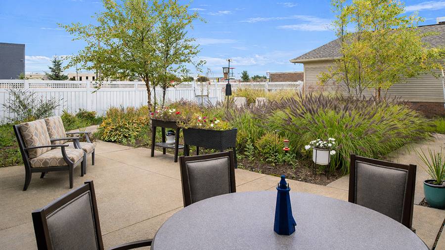 Outdoor patio and garden at American House Freedom Place Roseville, a memory care community in Roseville, Michigan