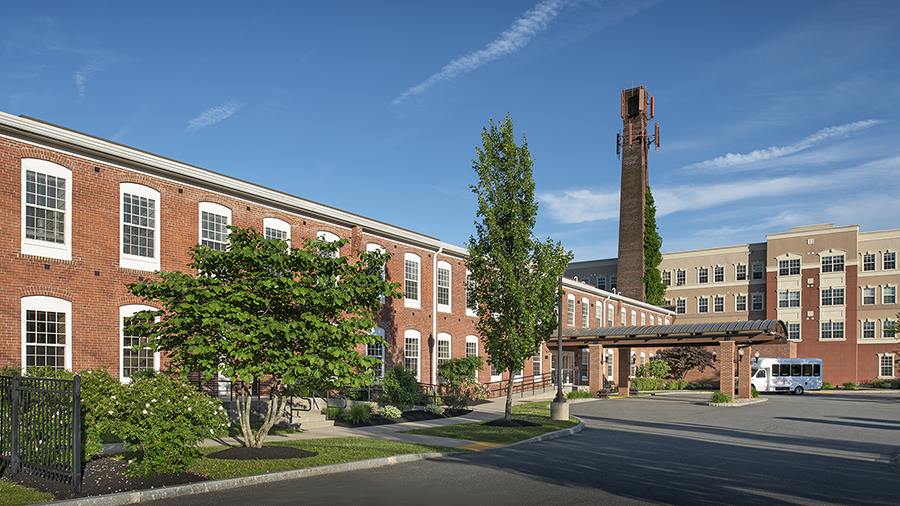 Front entrance and driveway with shuttle at American House Keene senior living community in Keene, NH