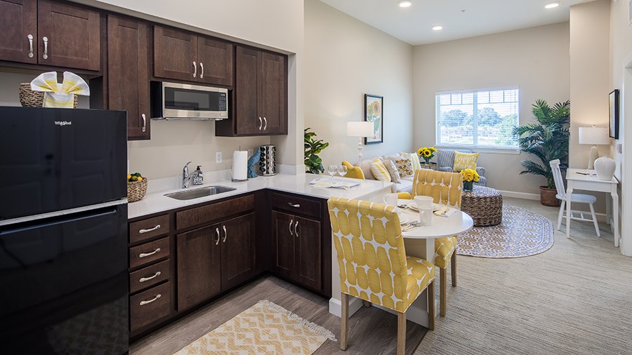 Model kitchen and living room at American House St. Petersburg Independent Living, Assisted Living, and Memory Care senior living facility in St. Petersburg, FL