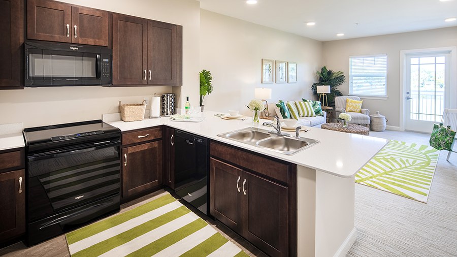 Model 2 kitchen and living room at American House St. Petersburg Independent Living, Assisted Living, and Memory Care senior living facility in St. Petersburg, FL