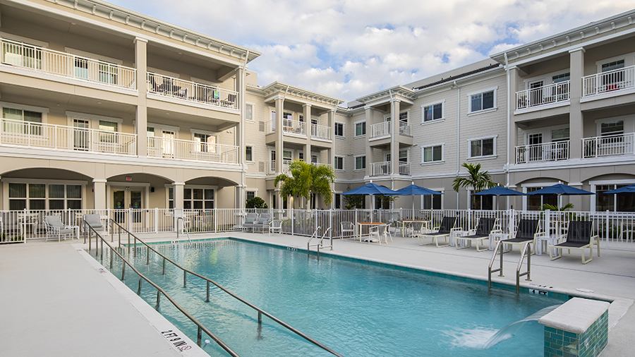 Patio and heated outdoor pool at American House St. Petersburg Independent Living, Assisted Living, and Memory Care senior living facility in St. Petersburg, FL