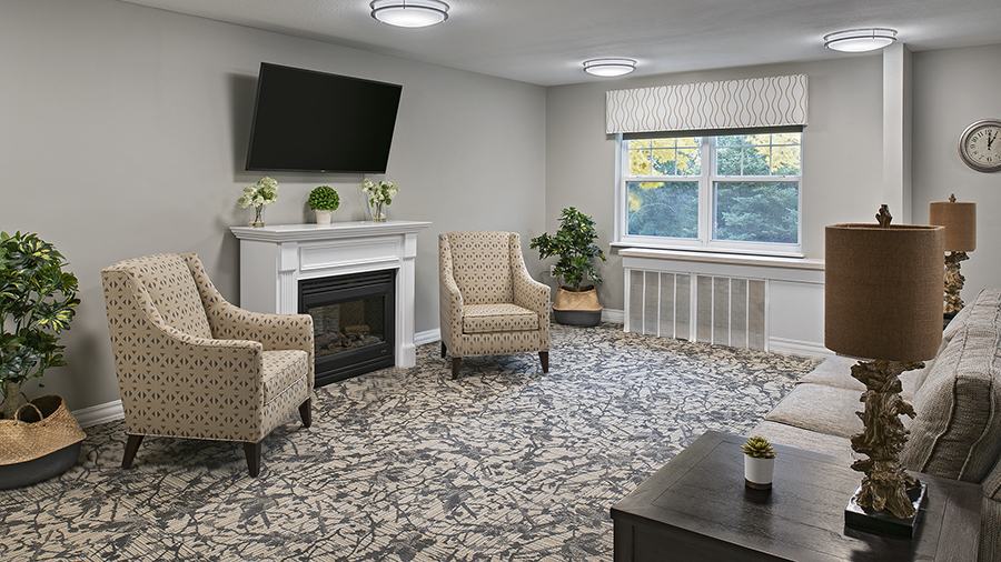 Cozy common area with fireplace at American House Village of Rochester Senior Living Community in Rochester Hills, MI