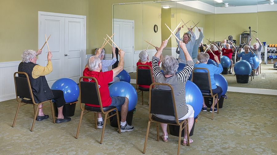 Fitness class in exercise room with modern equipment at American House Wildwood, an assisted living facility in Wildwood, FL