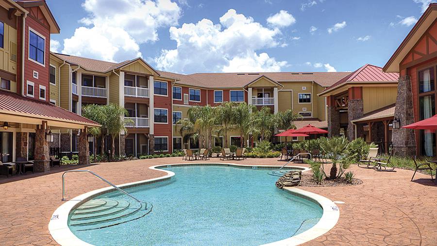 Outdoor pool with patio at American House Wildwood, an assisted living facility in Wildwood, FL