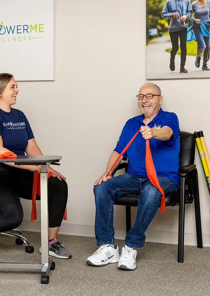 Resident at American House St. Anthony's senior living community with therapist doing exercise