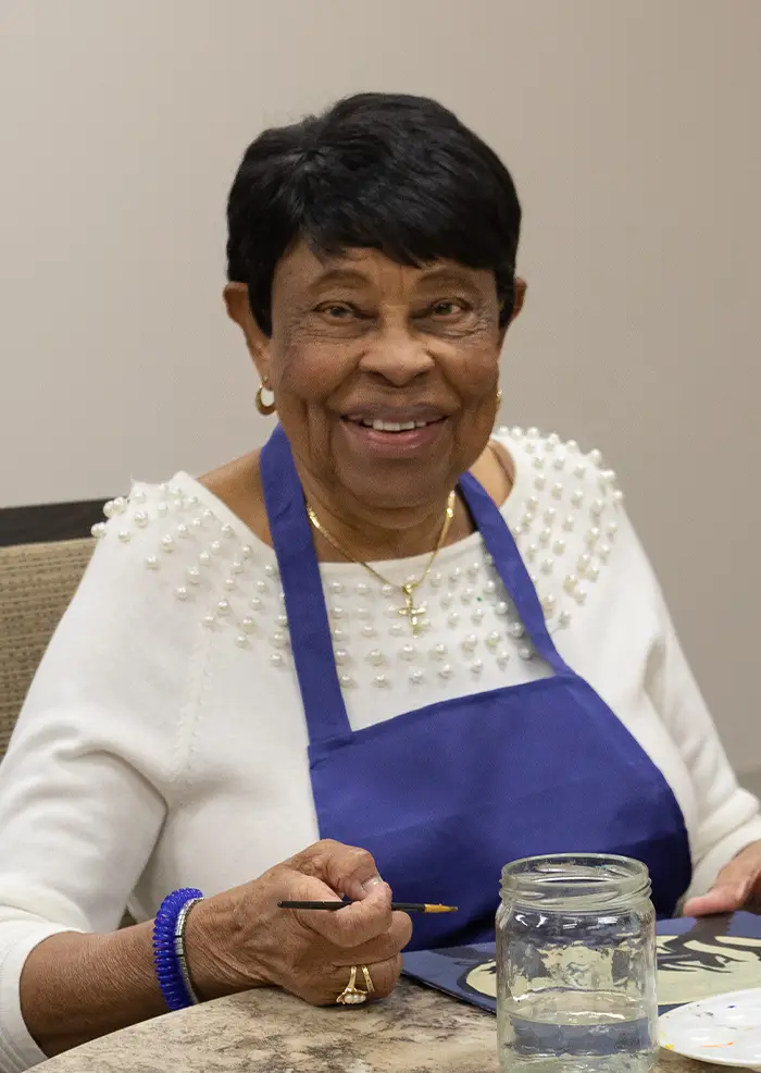 Resident at American House St. Anthony's senior living community painting adsf